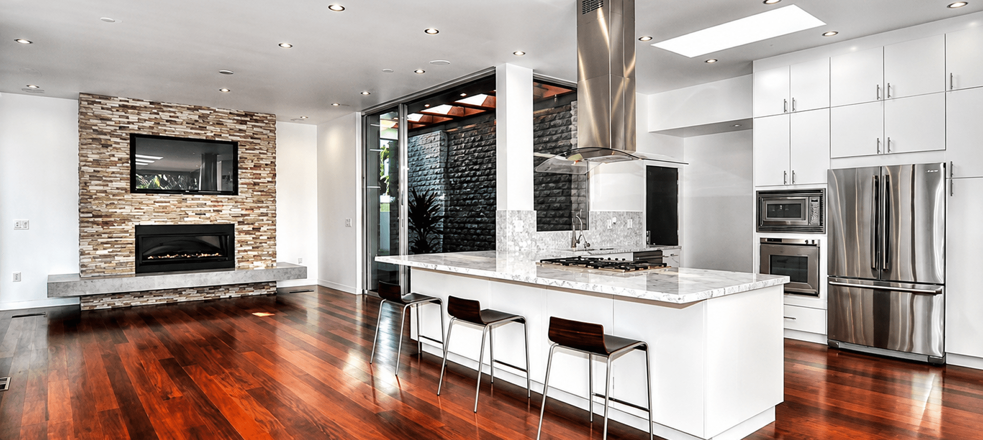 Modern kitchen with island and hardwood floor.