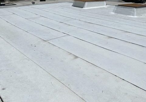 Flat white rooftop with clear blue sky.