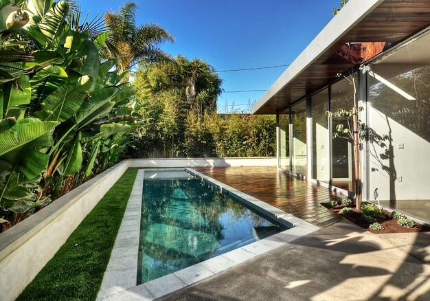 Glass-walled home overlooking tropical lap pool