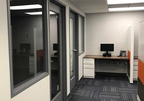 Glass-paneled hallway leading to a desk