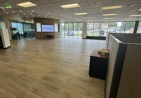 Spacious office interior with wooden flooring.