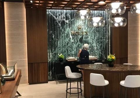 Luxury watch store interior with seated customer.